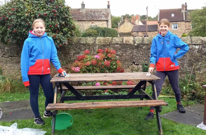 Guides get to work sprucing up shabby benches and picnic table